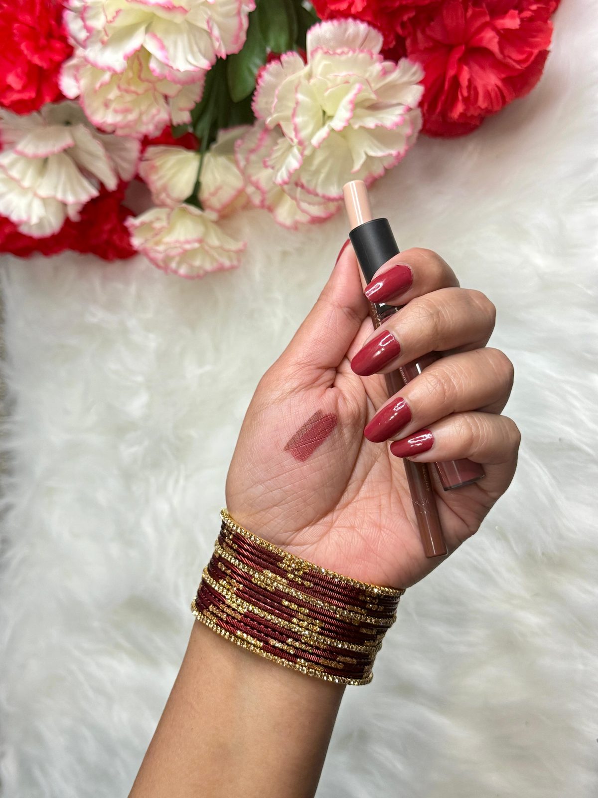 Maroon and gold bangles with lip swatch