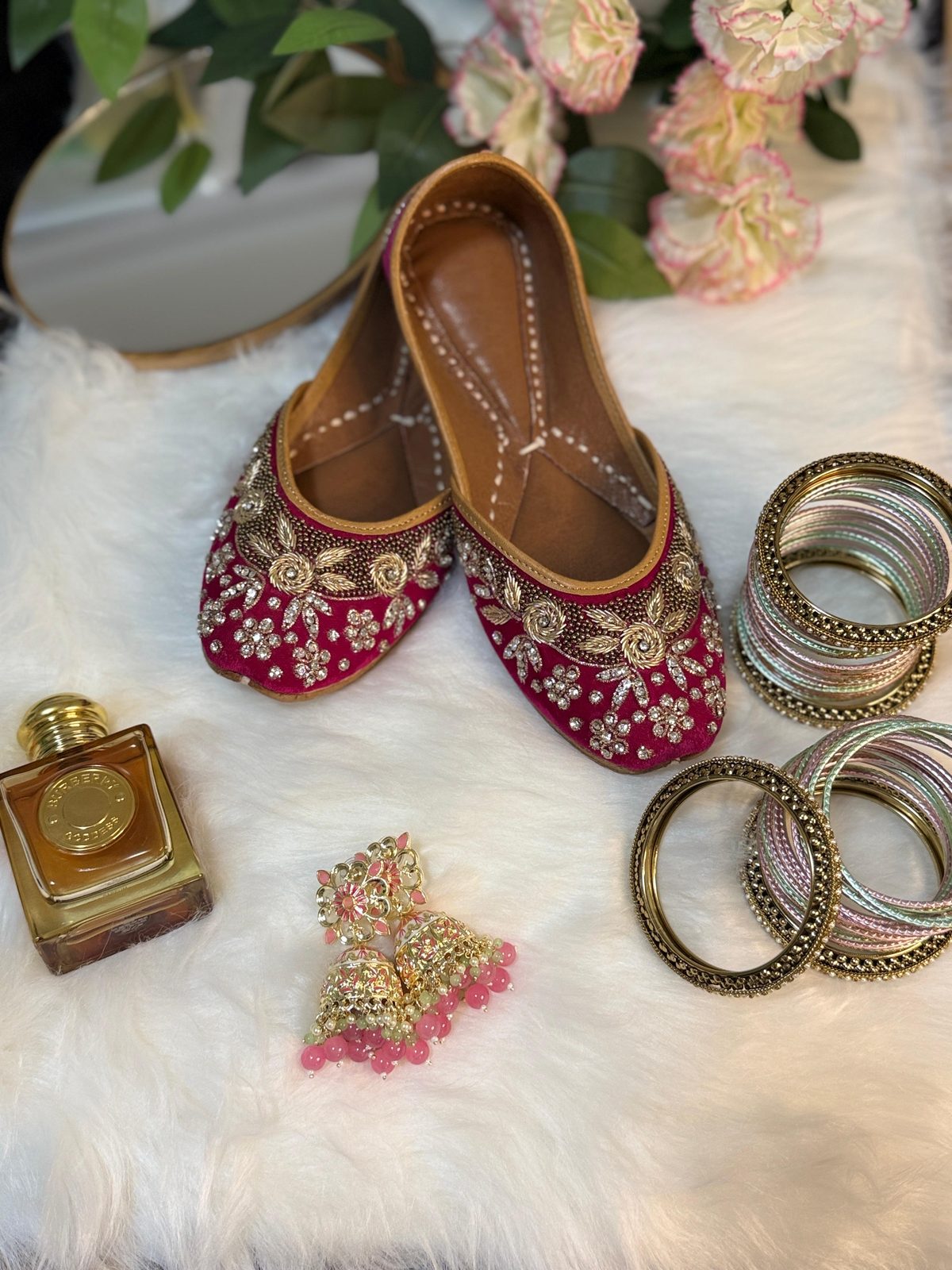 Magenta embellished juttis with pastel bangle stack and pink carnations